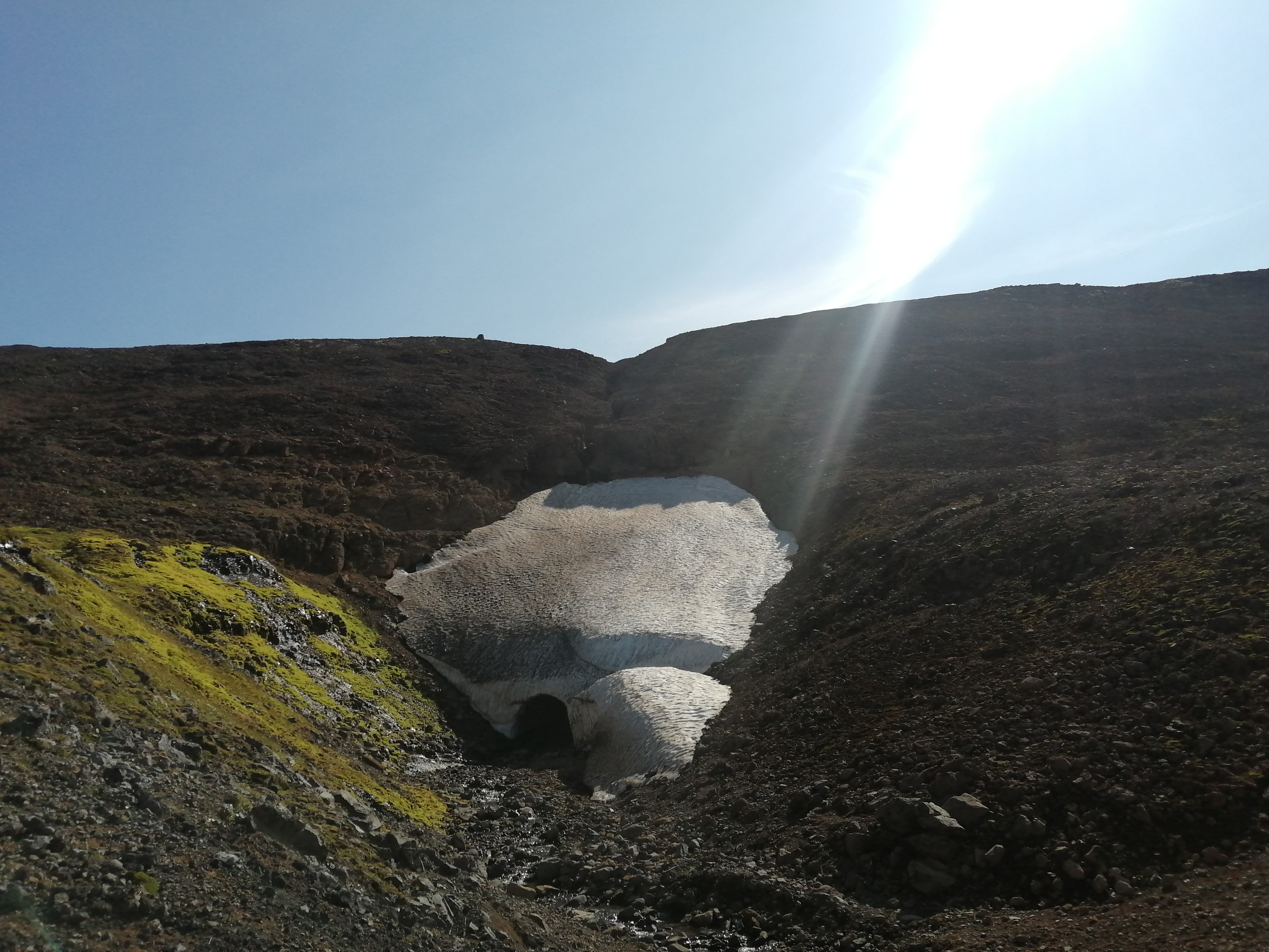 Un gros paquet de neige éternelle avec une petite entrée qui mène à un tunnel de glace.