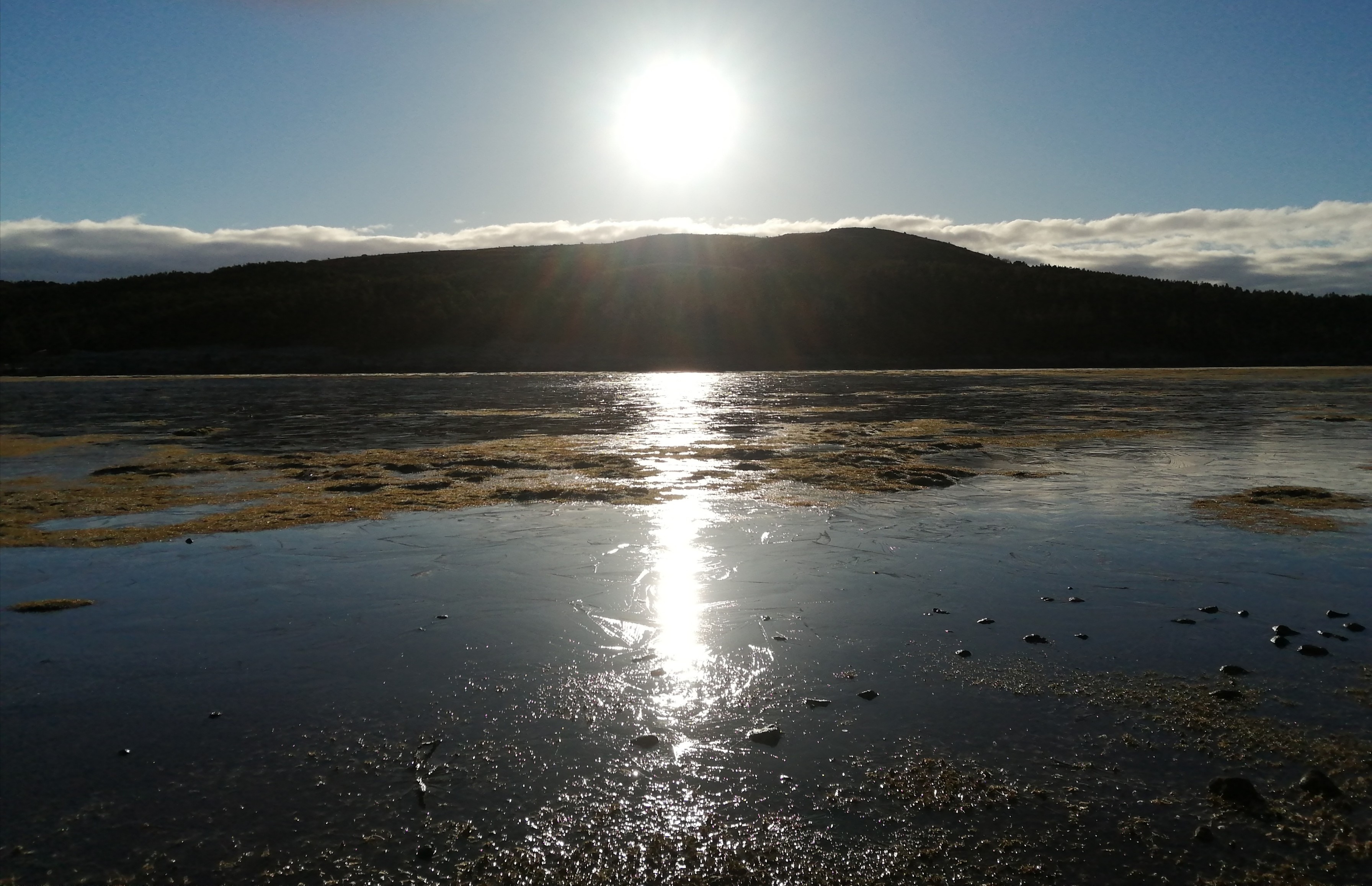 Une partie du lac gelé où se reflète le soleil.